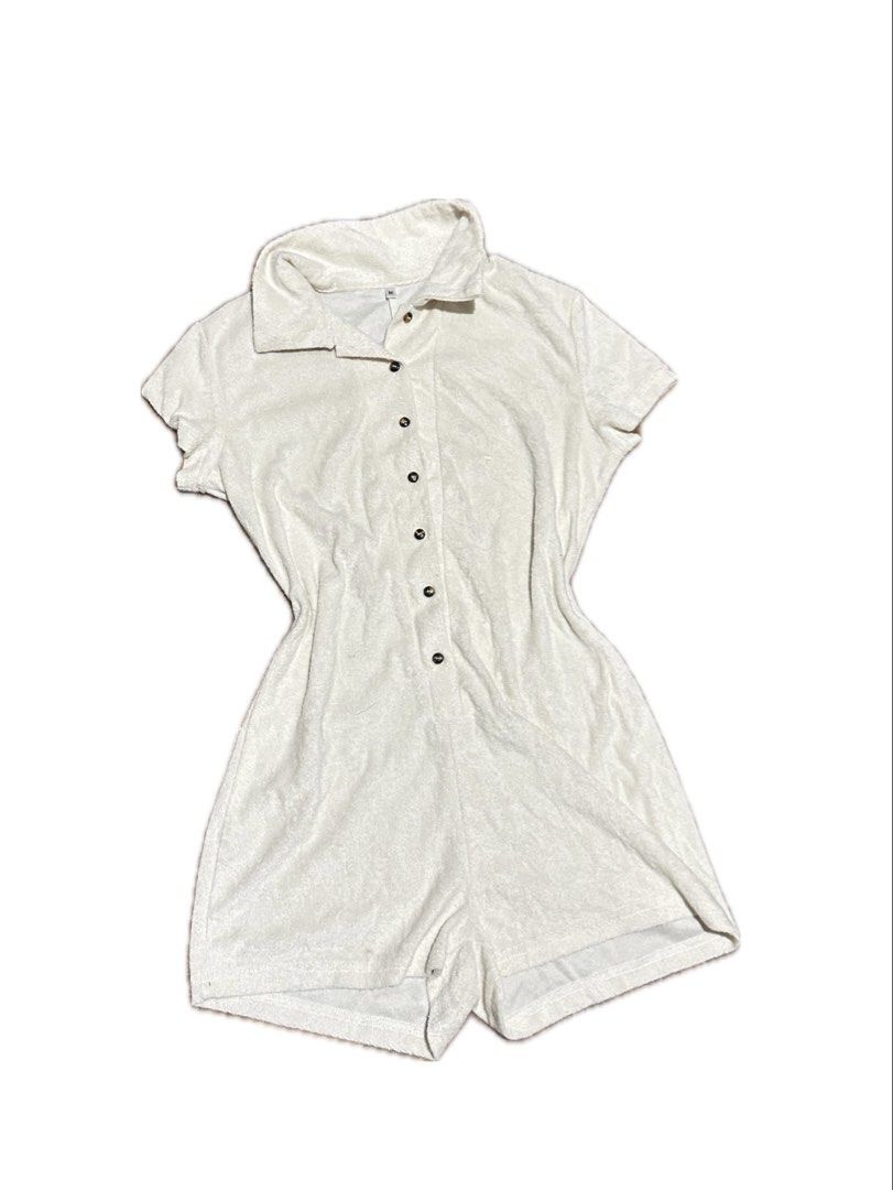 Beige Terrycloth Polo Romper Shorts (Category: Rompers) located in Manila. Submitted by yumidrobeee (Listing ID 1468544907, Image 1). Description: - Color: White - Size: Medium (tag attached) - Material: Soft, towel-like terrycloth fabric - Design: Short sleeves, polo collar, and button-down front with dark buttons - Fit: Fitted waistline for a flattering one-piece silhouette - Condition: Brand new / excellent - Perfect for: Casual, warm-weather 