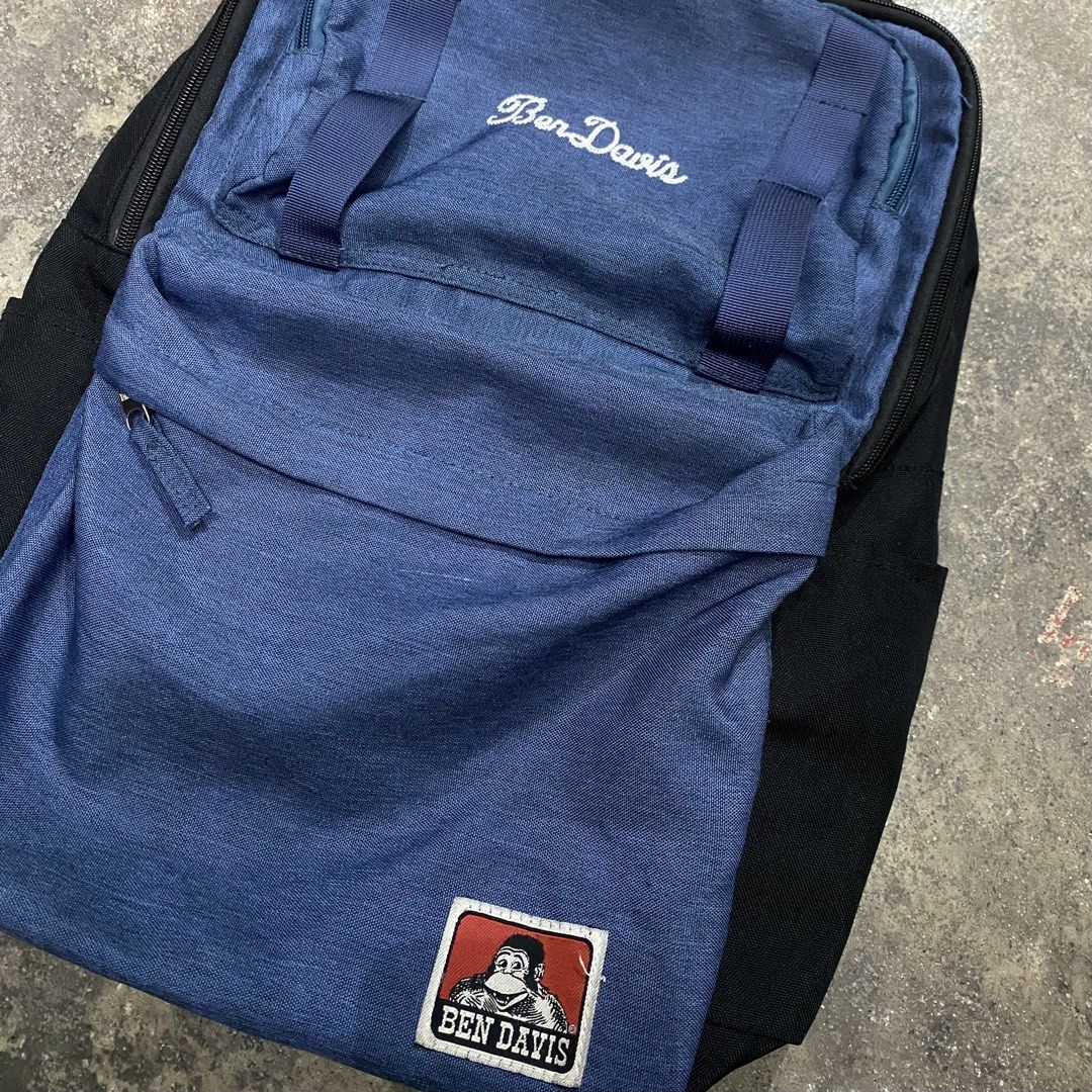 Ben Davis Blue Black Backpack (Category: Backpacks) located in Quezon City. Submitted by mgc_thriftshop (Listing ID 1468688814, Image 3). Description: - Brand: Ben Davis - Color: Blue and black - Material: Durable canvas-like fabric - Design details: Embroidered script logo and iconic gorilla patch - Features: Multiple compartments with branded metal zippers, padded straps, and top carry handle - Condition: Excellent, ideal for school or daily co