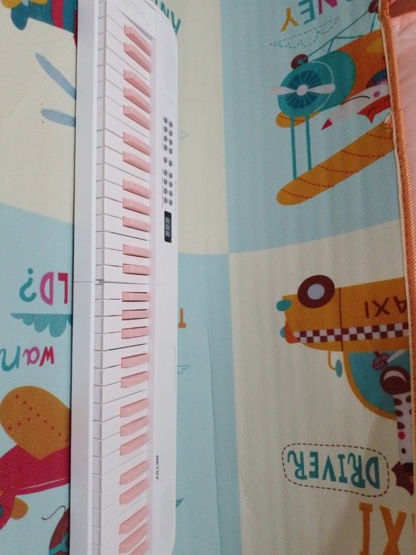 BETSY Roll Up Electronic Piano Keyboard White Pink (Category: Musical Instruments) located in Manila. Submitted by shanscrft (Listing ID 1468634411, Image 1). Description: - Brand: BETSY Portable Electronic Keyboard - Color: White body with adorable pink keys - Design: Foldable in half for easy storage and travel - Features: Digital display screen, built-in speaker, and control buttons for tone, volume, demo, rhythm, and record functions - Ideal 