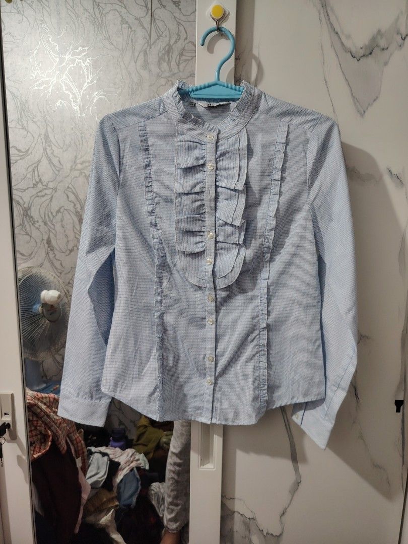 Biem Light Blue Checkered Ruffled Button-Down Blouse Size 36 (Category: Blouses) located in Valenzuela. Submitted by zealstar.48eb73 (Listing ID 1468668957, Image 1). Description: - Brand: Biem - Color: Light blue checkered - Size: 36 - Style: Long-sleeve fitted blouse with vertical panels - Details: Mandarin collar with front pleated ruffle accents and small white buttons - Condition: Excellent, clean fabric with no stains or loose threads - Mod