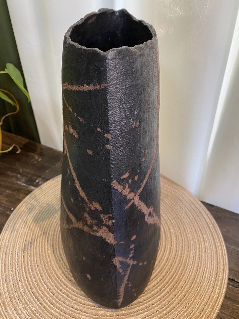 Black and Brown Textured Ceramic Vase Home Decor (Category: Vases & Decorative Bowls) located in San Pedro. Submitted by jingay81 (Listing ID 1468708763, Image 2). Description: - Height: Approx. 12 inches tall with an oval top opening - Design: Dark textured finish with abstract brownish paint strokes - Quality: Heavy and sturdy piece - Versatility: Ideal as a standalone display or for holding dried branches - Aesthetic: Neutral earth tones that 
