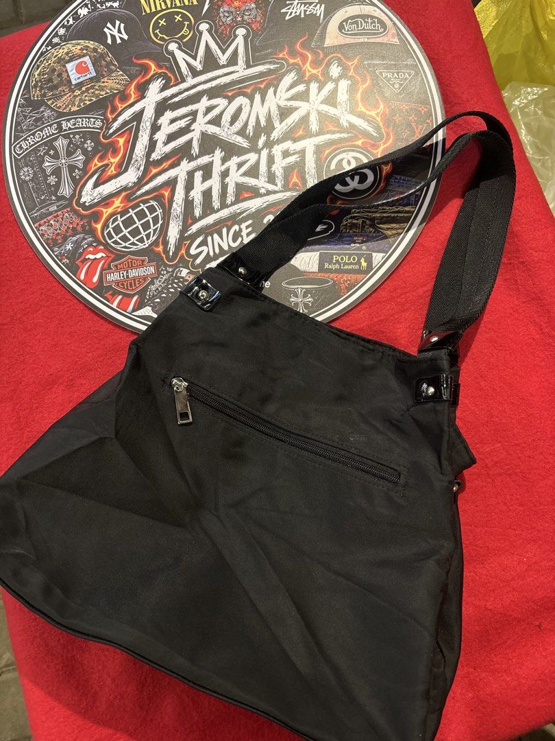 Black Nylon Shoulder Bag with Large Round Logo Patch (Category: Shoulder Bags) located in Manila. Submitted by jeromskito66462 (Listing ID 1468677194, Image 2). Description: - Color: Black - Material: Durable nylon with shiny patent leather tabs - Design: Large glossy circular front patch with cross emblem - Closure: Secure top zip with silver hardware and ring pull - Storage: Roomy main compartment plus an extra zippered back pocket - Style: Per