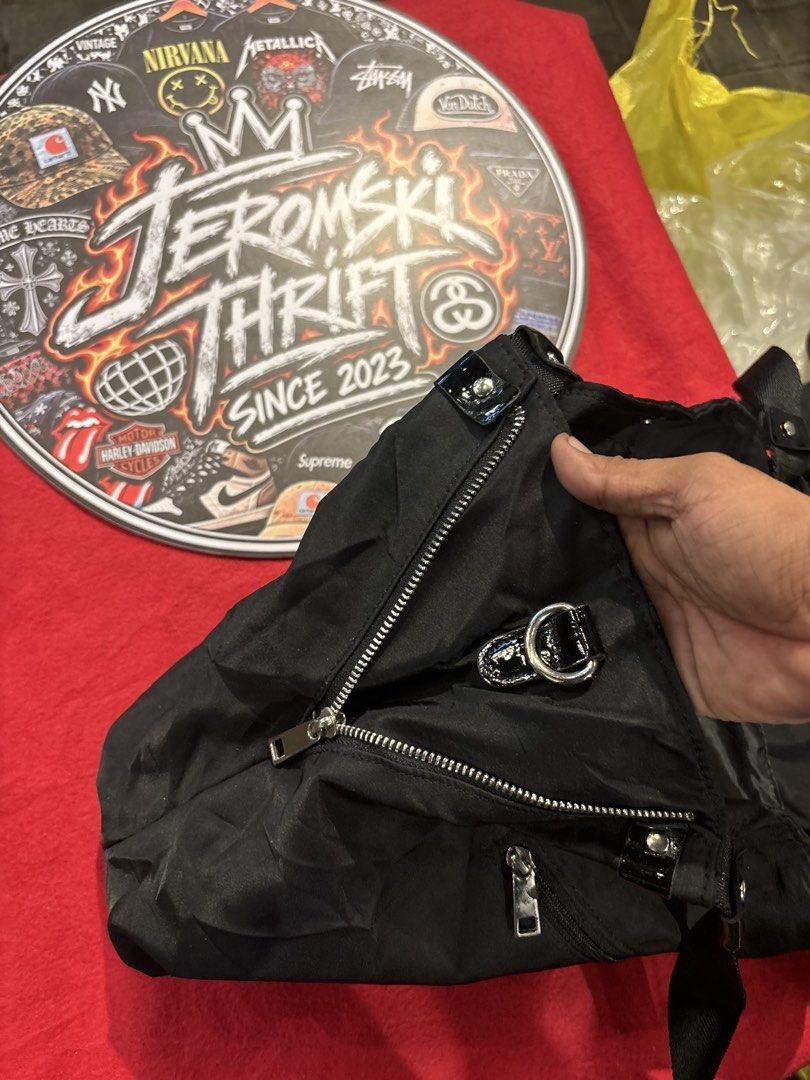 Black Nylon Shoulder Bag with Large Round Logo Patch (Category: Shoulder Bags) located in Manila. Submitted by jeromskito66462 (Listing ID 1468677194, Image 3). Description: - Color: Black - Material: Durable nylon with shiny patent leather tabs - Design: Large glossy circular front patch with cross emblem - Closure: Secure top zip with silver hardware and ring pull - Storage: Roomy main compartment plus an extra zippered back pocket - Style: Per