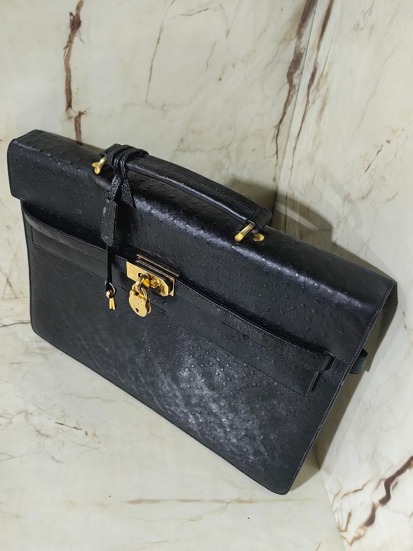 Black ostrich emboss leather briefcase with gold hardware lock (Category: Briefcases) located in Tarlac. Submitted by jeremiah.curator.2026 (Listing ID 1468534748, Image 3). Description: - Material: Genuine black ostrich emboss leather with unique textured quill pattern - Hardware: Elegant gold metal turn-lock closure, matching padlock, clochette, and keys included - Design: Structured rectangular shape with front flap closure and clean edge stit