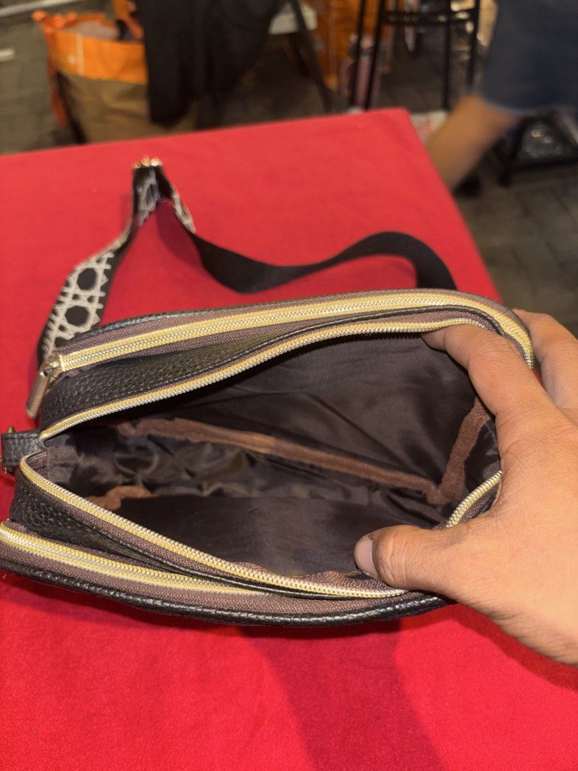 Black Quilted Crossbody Bag with Patterned Strap (Category: Cross-body Bags) located in Manila. Submitted by jeromskito66462 (Listing ID 1468673209, Image 3). Description: - Color & Material: Black textured faux leather with chic gold-toned hardware - Design: Elegant quilted pattern with a front metal plaque - Compartments: Two main zippered compartments with a clean brown fabric lining - Strap: Wide, adjustable black and white geometric pattern 