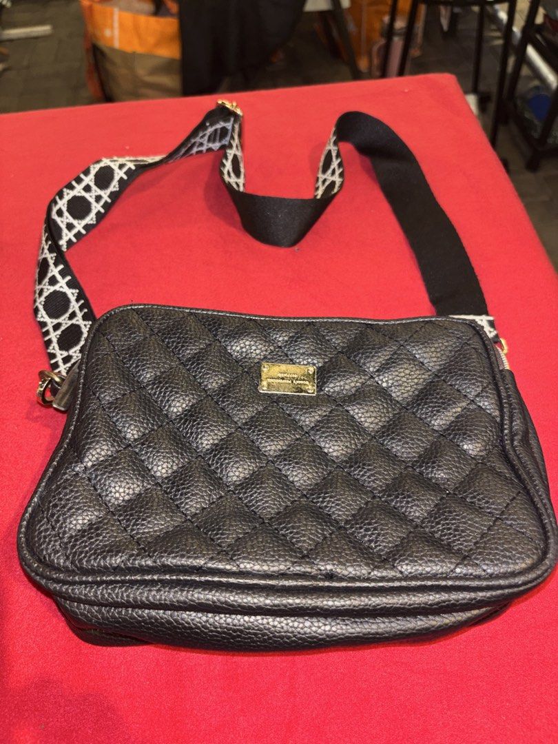 Black Quilted Crossbody Bag with Patterned Strap (Category: Cross-body Bags) located in Manila. Submitted by jeromskito66462 (Listing ID 1468673209, Image 2). Description: - Color & Material: Black textured faux leather with chic gold-toned hardware - Design: Elegant quilted pattern with a front metal plaque - Compartments: Two main zippered compartments with a clean brown fabric lining - Strap: Wide, adjustable black and white geometric pattern 
