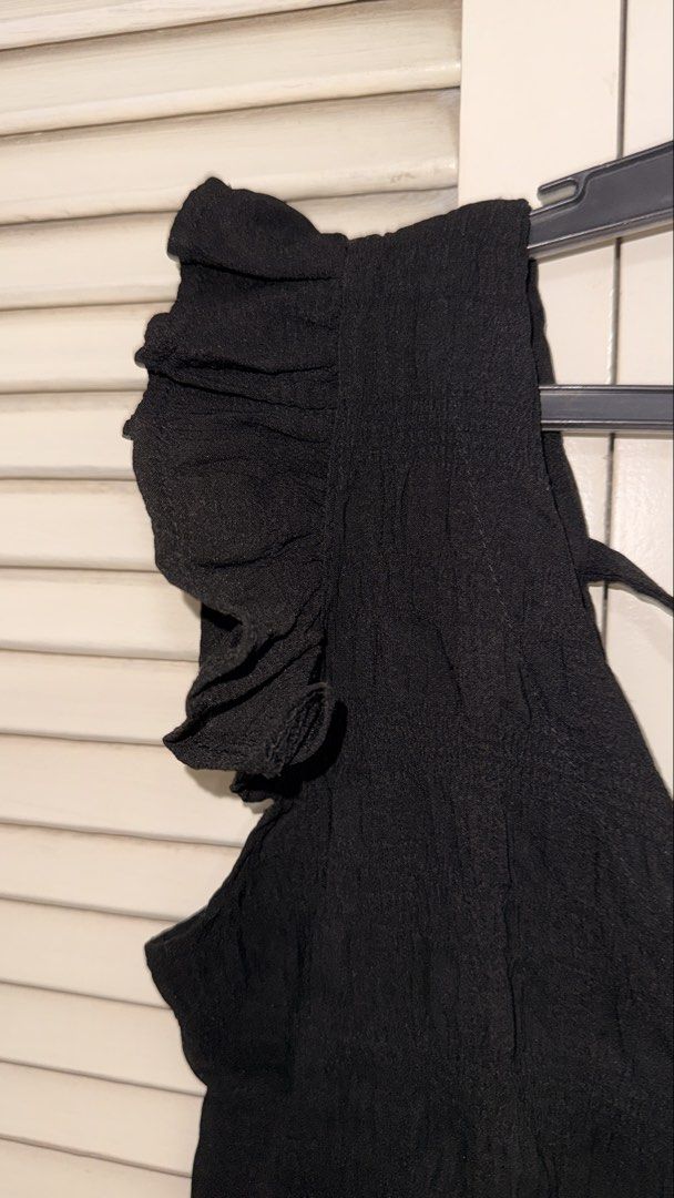 Black Ruffle Strap Crop Top with Tie Back (Category: Sleeveless) located in Manila. Submitted by oliviablanche (Listing ID 1468607186, Image 2). Description: - Color: Black - Style: Crop top with V-neckline (front & back) - Details: Wide ruffle straps, ruffle hem, and secure back-tie cross straps - Fabric: Textured with slight stretch for comfort - Versatility: Great for daily wear; easy to match with jeans or high-waisted skirts - Condition: Lik