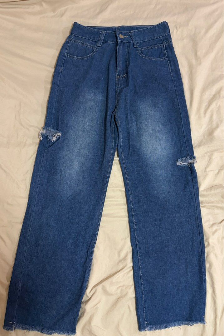 Blue Distressed Denim Jeans with Raw Hem size 26 (Category: Jeans) located in Mandaluyong City. Submitted by afterceej (Listing ID 1468668889, Image 3). Description: - Style: High-waisted denim jeans -Size: 26 - Color: Medium wash blue with light thigh fading - Closure: Button fly with belt loops - Details: Distressed knee cutouts and raw frayed hems - Pockets: Standard front and back pockets.