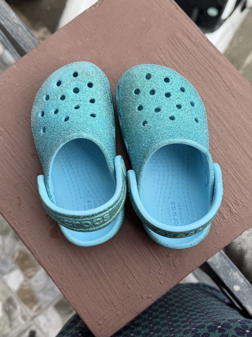 Blue Glitter Kids Crocs Clogs size C7 (Category: Babies & Kids Fashion) located in Makati City. Submitted by _kath01 (Listing ID 1468670007, Image 1). Description: - Authentic Kids' Sparkly Blue Crocs - Fun and sparkly finish that kids adore - Classic slip-on design with secure pivoting heel straps - Breathable ventilation holes on top - Cushioned with Iconic Crocs Comfort insoles - Water-friendly, quick-drying, and easy to clean - Ideal for the 