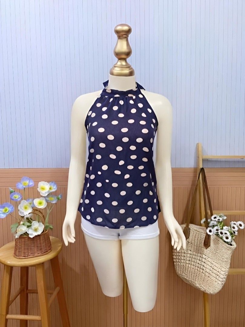 Blue Polka Dot Halter Top (Category: Blouses) located in Roxas City. Submitted by blairnstyle (Listing ID 1468614738, Image 1). Description: Color & Pattern: Dark navy blue base featuring a classic all-over off-white polka dot print. ​Neckline: High-neck halter style with subtle gathered detailing around the collar. ​Sleeves: Sleeveless cut. ​Style: Retro-chic and versatile, ideal for pairing with casual shorts, jeans, or skirts..