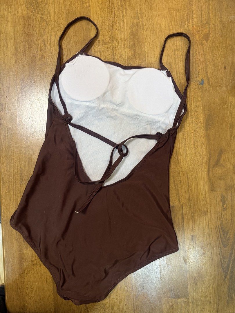 Brown One-Piece Swimsuit with Back Straps (Category: Bikinis & Swimsuits) located in Makati City. Submitted by shoprory (Listing ID 1468597603, Image 2). Description: - Color: Solid Brown - Style: Classic one-piece with chic lower back criss-cross straps and spaghetti straps - Padding: Includes removable white chest pads - Material: Smooth, highly stretchy, and comfortable fabric - Lining: Clean, high-quality inner lining - Perfect for: Beach get