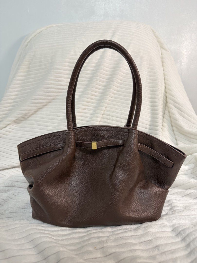 Brown Pebbled Leather Tote Bag with Gold Hardware (Category: Tote Bags) located in Rizal. Submitted by kianapreloves (Listing ID 1468590366, Image 1). Description: - Material: Rich brown textured leather - Handles: Double top handles for easy carrying - Details: Chic center front strap with a small gold-tone metal accent - Closure: Open top design with a secure magnetic snap - Interior: Light-colored patterned fabric lining with a roomy compartme