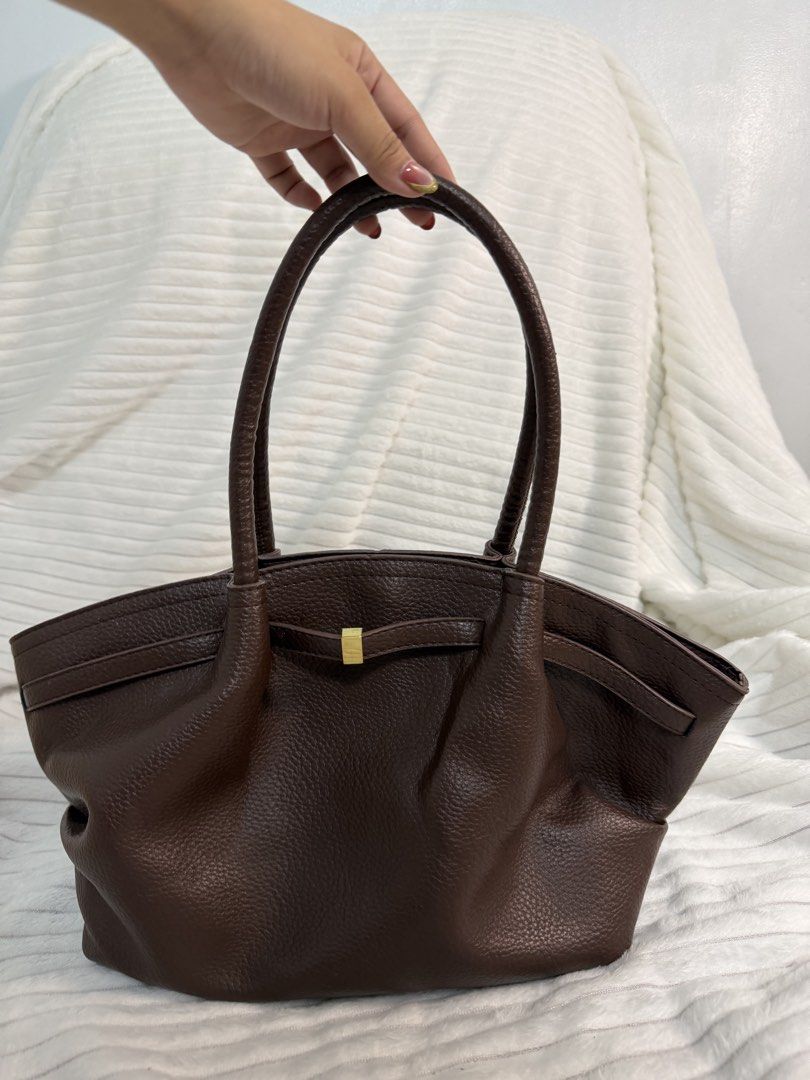 Brown Pebbled Leather Tote Bag with Gold Hardware (Category: Tote Bags) located in Rizal. Submitted by kianapreloves (Listing ID 1468590366, Image 2). Description: - Material: Rich brown textured leather - Handles: Double top handles for easy carrying - Details: Chic center front strap with a small gold-tone metal accent - Closure: Open top design with a secure magnetic snap - Interior: Light-colored patterned fabric lining with a roomy compartme