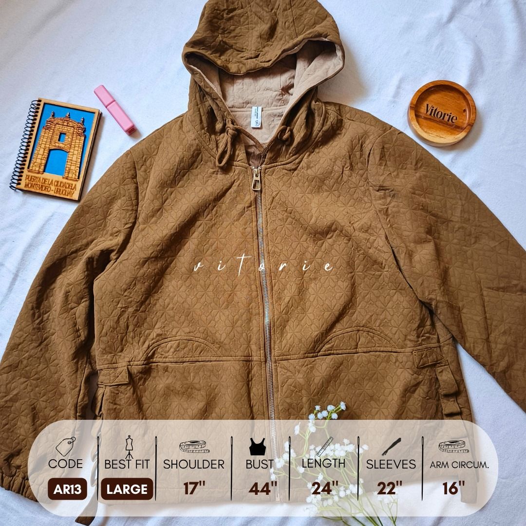 Brown Quilted Hooded Jacket Size Large AR13 (Category: Coats, Jackets and Outerwear) located in Cabuyao City. Submitted by vitorieclothing_lifestyle (Listing ID 1468508306, Image 1). Description: - Style: Brown quilted jacket with full zip and attached hood - Fit: Best fits Large (Shoulder: 17", Bust: 44", Length: 24", Sleeves: 22", Arm Circumference: 16") - Features: Textured fabric pattern, front pockets, adjustable side tabs - Perfect for: War