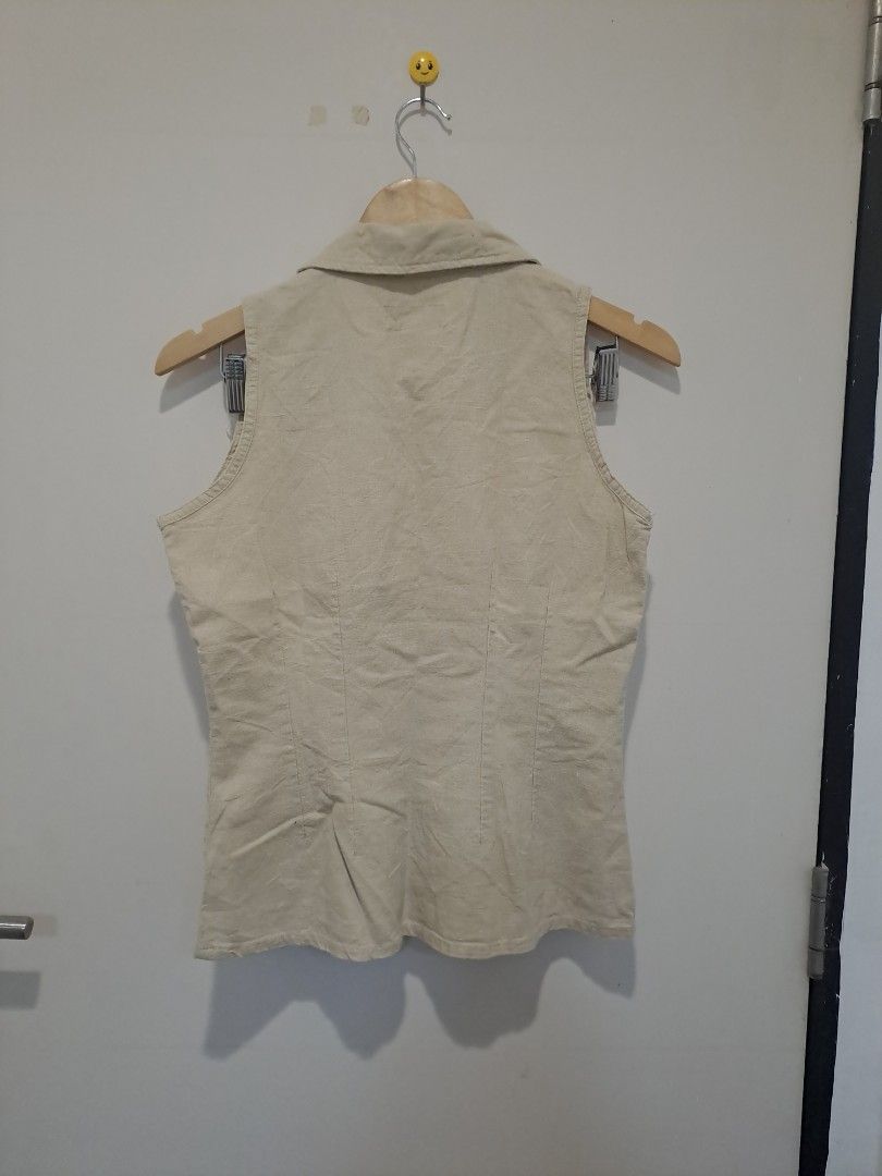BUFFALO JEANS 100% LINEN (Category: Sleeveless) located in Manila. Submitted by joanbalde39643 (Listing ID 1468611780, Image 3). Description: This is a vintage beige sleeveless button-up shirt styled with a point collar, front princess seams for a tailored fit, and dual pointed chest pockets with button closures. It features a retro, safari-inspired or western aesthetic that works excellently as a standalone top or layered open over a tank.