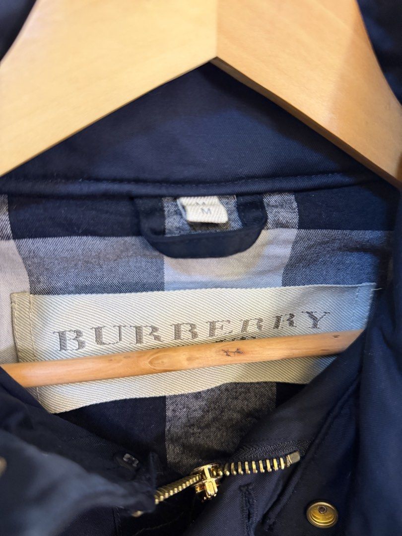 Burberry Black Hooded Utility Jacket Size M (Category: Coats, Jackets and Outerwear) located in Paranaque City. Submitted by mykapoynton (Listing ID 1468702634, Image 3). Description: - Brand: Burberry - Color: Black - Size: Medium (M) - Material: 100% cotton main fabric - Design: Multiple front flap pockets with button closures and gold-tone hardware - Features: Attached hood at the collar and classic Burberry check interior lining - Origin: Mad