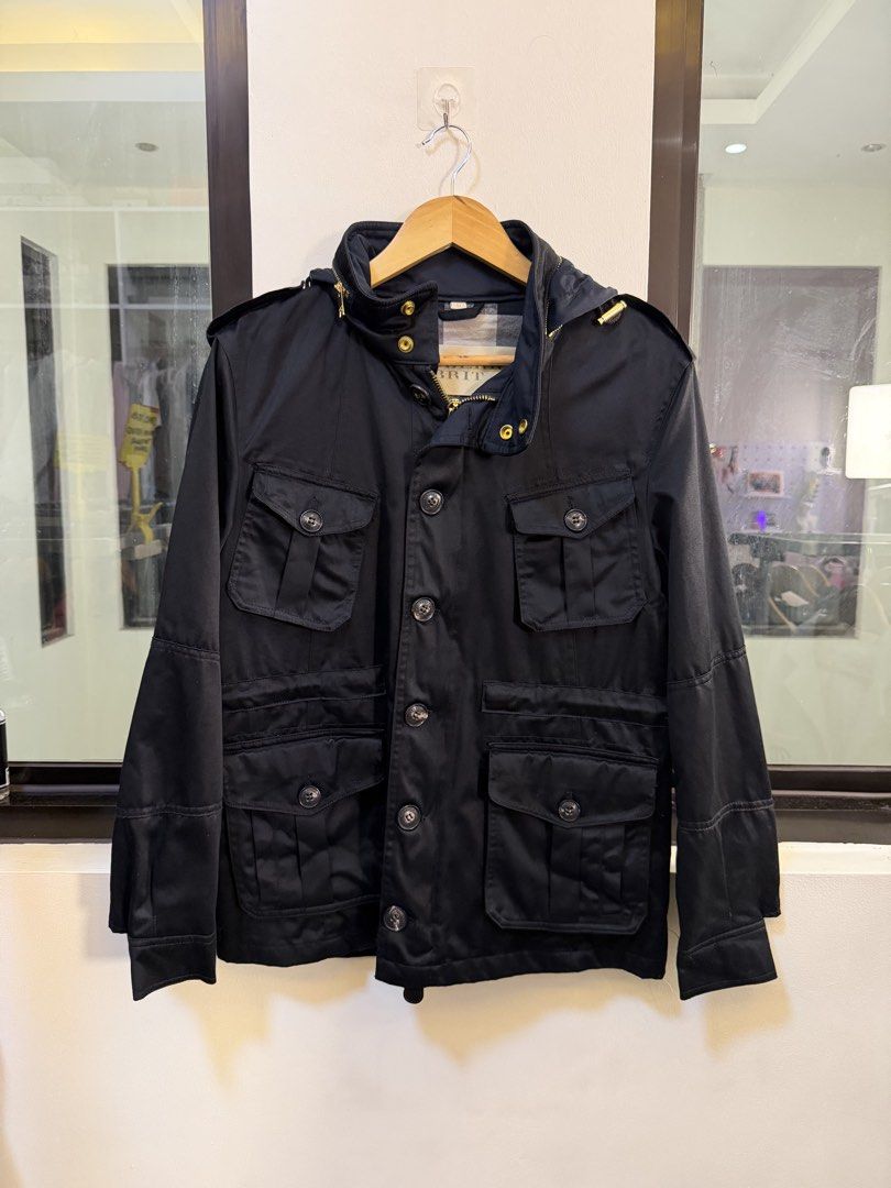 Burberry Black Hooded Utility Jacket Size M (Category: Coats, Jackets and Outerwear) located in Paranaque City. Submitted by mykapoynton (Listing ID 1468702634, Image 2). Description: - Brand: Burberry - Color: Black - Size: Medium (M) - Material: 100% cotton main fabric - Design: Multiple front flap pockets with button closures and gold-tone hardware - Features: Attached hood at the collar and classic Burberry check interior lining - Origin: Mad