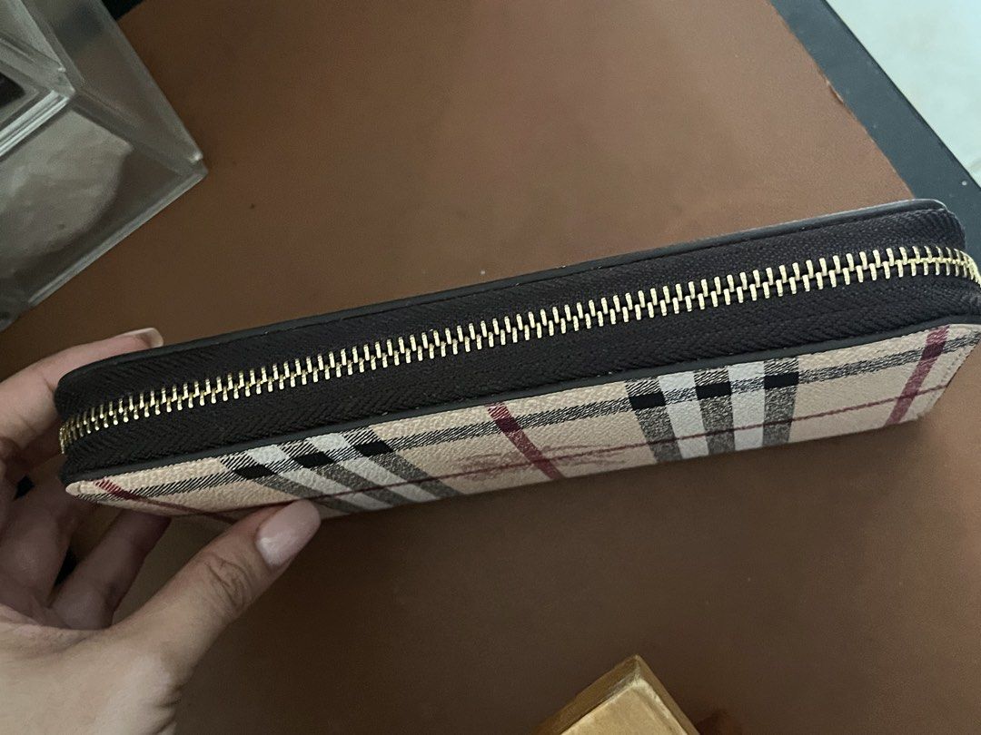 Burberry Check Zip Around Wallet (Category: Luxury Bags & Wallets) located in Malolos. Submitted by magnoannchrstn (Listing ID 1468514386, Image 2). Description: - Burberry check print with iconic equestrian knight logo - Secure zip-around closure with smooth gold-tone hardware - Classic beige, black, and red plaid colorway - Spacious interior with plenty of room for cards and cash - Clean stitching and structured, premium shape.