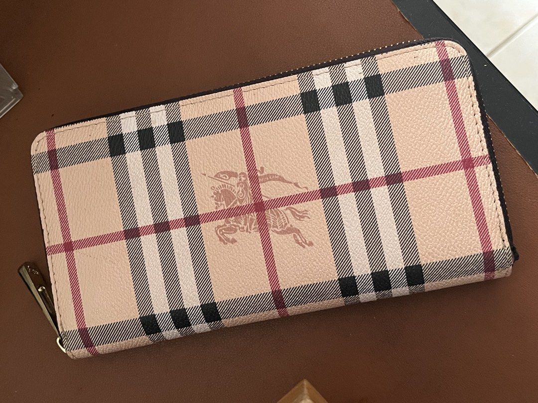 Burberry Check Zip Around Wallet (Category: Luxury Bags & Wallets) located in Malolos. Submitted by magnoannchrstn (Listing ID 1468514386, Image 1). Description: - Burberry check print with iconic equestrian knight logo - Secure zip-around closure with smooth gold-tone hardware - Classic beige, black, and red plaid colorway - Spacious interior with plenty of room for cards and cash - Clean stitching and structured, premium shape.
