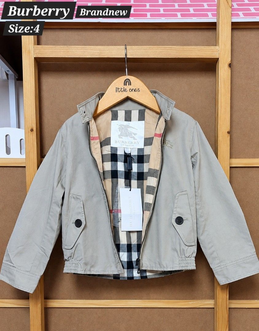 Burberry Children Jacket Size 4 (Category: Babies & Kids Fashion) located in Caloocan City. Submitted by clairyyyyy (Listing ID 1468659428, Image 1). Description: - Authentic Burberry children jacket in classic beige - Cotton outer fabric with signature check lining - Front zip closure with top collar button - Two functional buttoned flap pockets - Long sleeves with structured cuffs - Brand tags still attached - Includes extra button in a sealed 