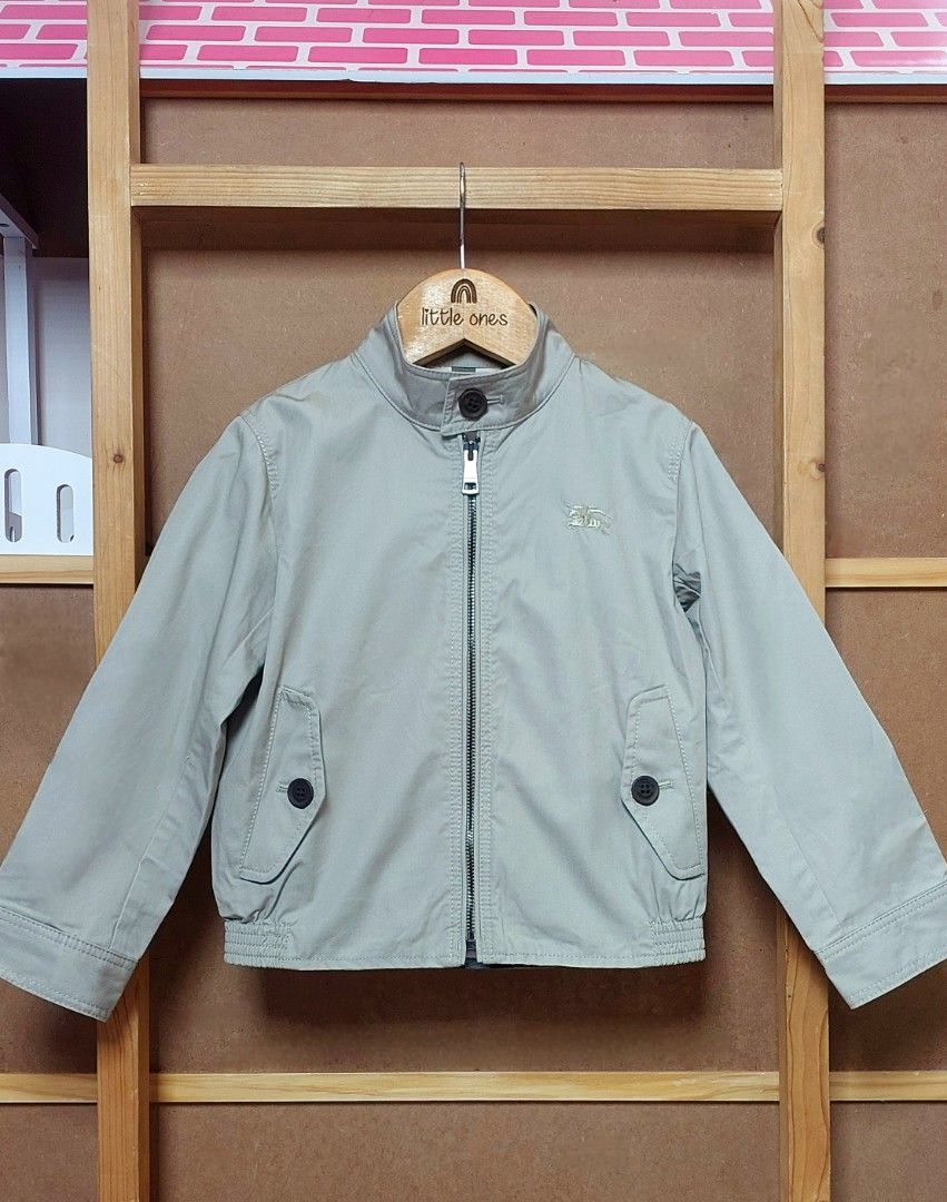 Burberry Children Jacket Size 4 (Category: Babies & Kids Fashion) located in Caloocan City. Submitted by clairyyyyy (Listing ID 1468659428, Image 3). Description: - Authentic Burberry children jacket in classic beige - Cotton outer fabric with signature check lining - Front zip closure with top collar button - Two functional buttoned flap pockets - Long sleeves with structured cuffs - Brand tags still attached - Includes extra button in a sealed 
