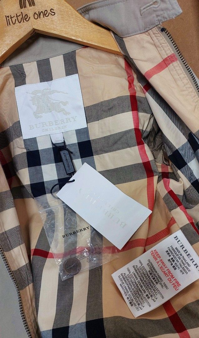 Burberry Children Jacket Size 4 (Category: Babies & Kids Fashion) located in Caloocan City. Submitted by clairyyyyy (Listing ID 1468659428, Image 2). Description: - Authentic Burberry children jacket in classic beige - Cotton outer fabric with signature check lining - Front zip closure with top collar button - Two functional buttoned flap pockets - Long sleeves with structured cuffs - Brand tags still attached - Includes extra button in a sealed 