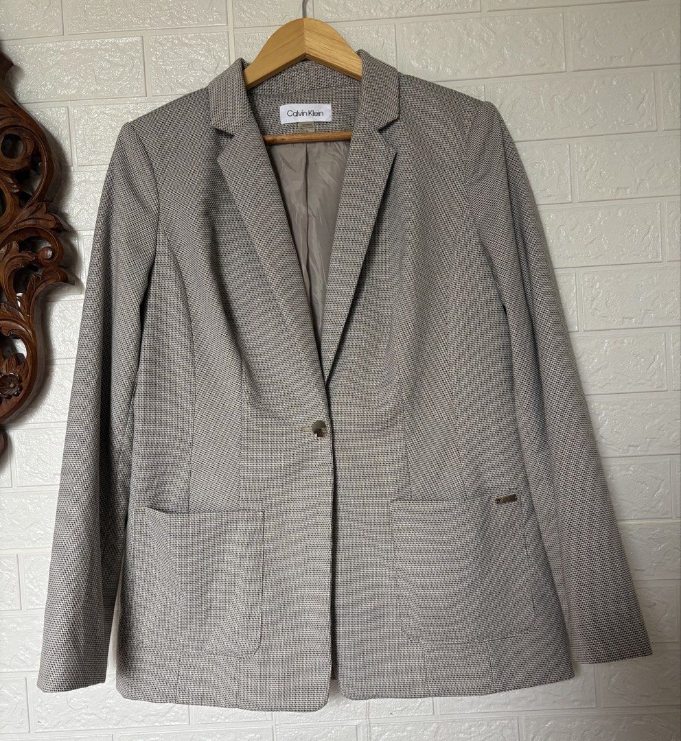 Calvin Klein Blazer (Category: Coats, Jackets and Outerwear) located in Batangas. Submitted by purple_and_orange (Listing ID 1468512041, Image 1). Description: - Brand: Calvin Klein - Size: 10 - Color/Pattern: Textured grey - Style: Single-button closure, notched lapels, and structured shoulders - Details: Two front patch pockets with subtle CK branding on the left pocket - Interior: Fully lined in light grey-taupe - Origin: Made in Indonesia - C