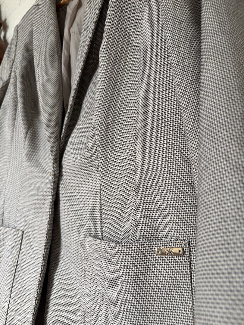 Calvin Klein Blazer (Category: Coats, Jackets and Outerwear) located in Batangas. Submitted by purple_and_orange (Listing ID 1468512041, Image 2). Description: - Brand: Calvin Klein - Size: 10 - Color/Pattern: Textured grey - Style: Single-button closure, notched lapels, and structured shoulders - Details: Two front patch pockets with subtle CK branding on the left pocket - Interior: Fully lined in light grey-taupe - Origin: Made in Indonesia - C