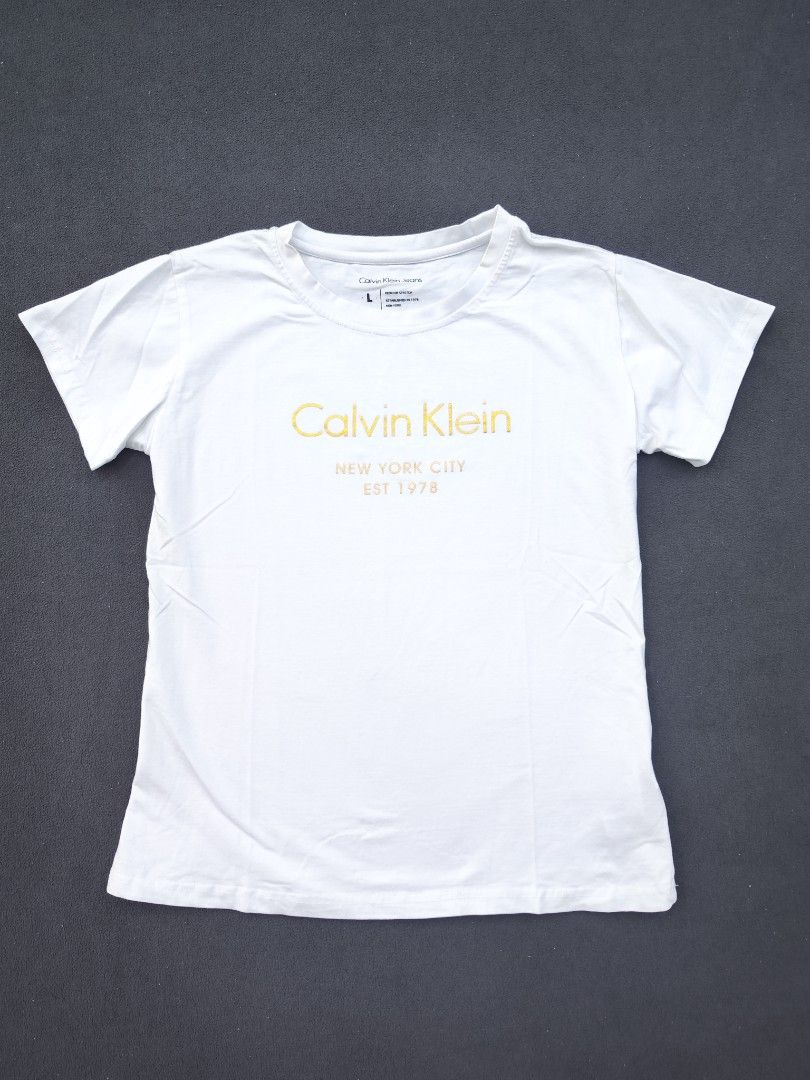 Calvin Klein Womens Tee (Category: Shirts) located in Bulacan. Submitted by emilj23 (Listing ID 1468521559, Image 1). Description: Calvin Klein Womens Tee Size L on tag L 23 W 17.5 Condition 9/10 Color rate 9/10 No Issue.