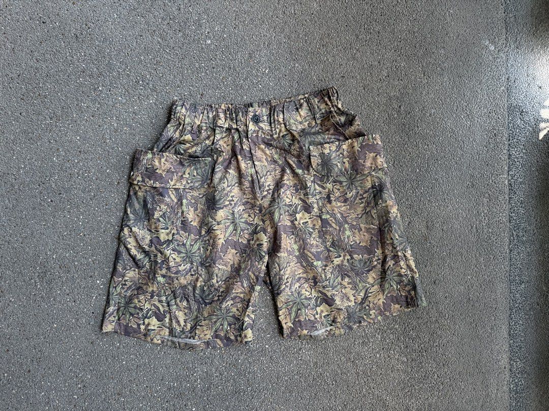 Camo Leaf Pattern Cargo Shorts with Elastic Waist (Category: Shorts) located in San Fernando. Submitted by houseof_jj (Listing ID 1468506142, Image 2). Description: USED SIZE:M - Woodland leaf and branch camouflage print in green, brown, and beige - Elastic waistband with a front button closure for a secure fit - Roomy flap pockets on both sides for extra storage - Lightweight fabric ideal for casual outdoor days or streetwear fits.
