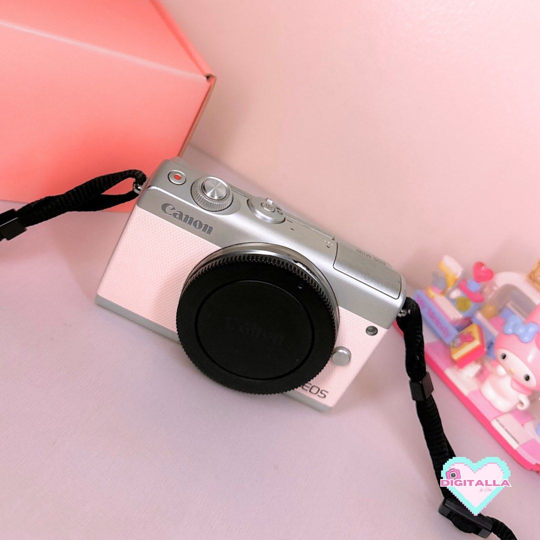 Canon EOS M100 in Pink Mirrorless Camera (Category: Cameras) located in Iloilo. Submitted by alyssadia (Listing ID 1468669623, Image 2). Description: 𝐂𝐚𝐧𝐨𝐧 𝐄𝐎𝐒 𝐌𝟏𝟎𝟎 (𝐏𝐢𝐧𝐤) — ₱22,999 ✧･ﾟ🩷📸 ┆ ⤿ 🌸 . ݁˖ 𝐃𝐄𝐓𝐀𝐈𝐋𝐒 ✧ 24.2MP APS-C CMOS Sensor ✧ Canon EF-M 15–45mm Kit Lens ✧ Full HD 1080p Video Recording ✧ Tilting LCD Screen (Selfie) ✧ Built-in Wi-Fi & Bluetooth ✧ Body Condition: 7.5/10 — paint chips, missing rubber port cover, si