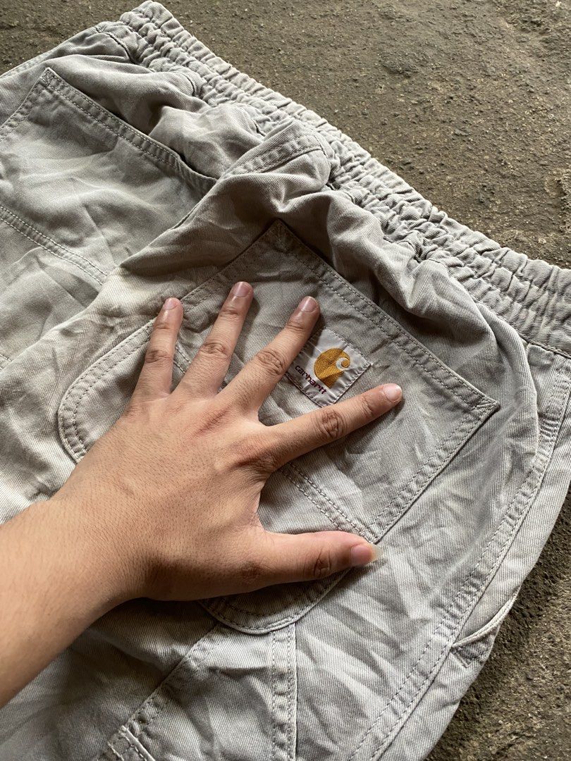 Carhartt Cargo Pants Grey Elastic Waist (Category: Jeans) located in Caloocan City. Submitted by remythrift (Listing ID 1468514974, Image 3). Description: - Brand: Carhartt - Color: Grey - Style: Utility work pants with relaxed fit - Waist: Elastic waistband with adjustable drawstring - Features: Multiple side tool pockets and classic back patch pockets with woven brand logo - Material: Durable cotton twill fabric - Condition: Genuine wear and fa