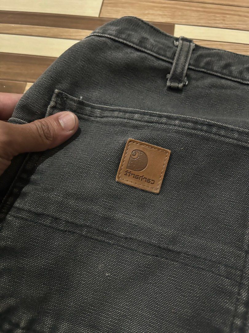 Carhartt Double Front Work Pants Black (Category: Jeans) located in Caloocan City. Submitted by wadxxx (Listing ID 1468594341, Image 3). Description: - Brand: Carhartt - Style: Double front work pants in black duck canvas - Condition: Faded wash with natural wear, authentic paint splatters, and slight hem fraying - Features: Heavy-duty cotton fabric, double knees, multiple utility pockets, and hammer loop - Details: Branded rivets and button clos