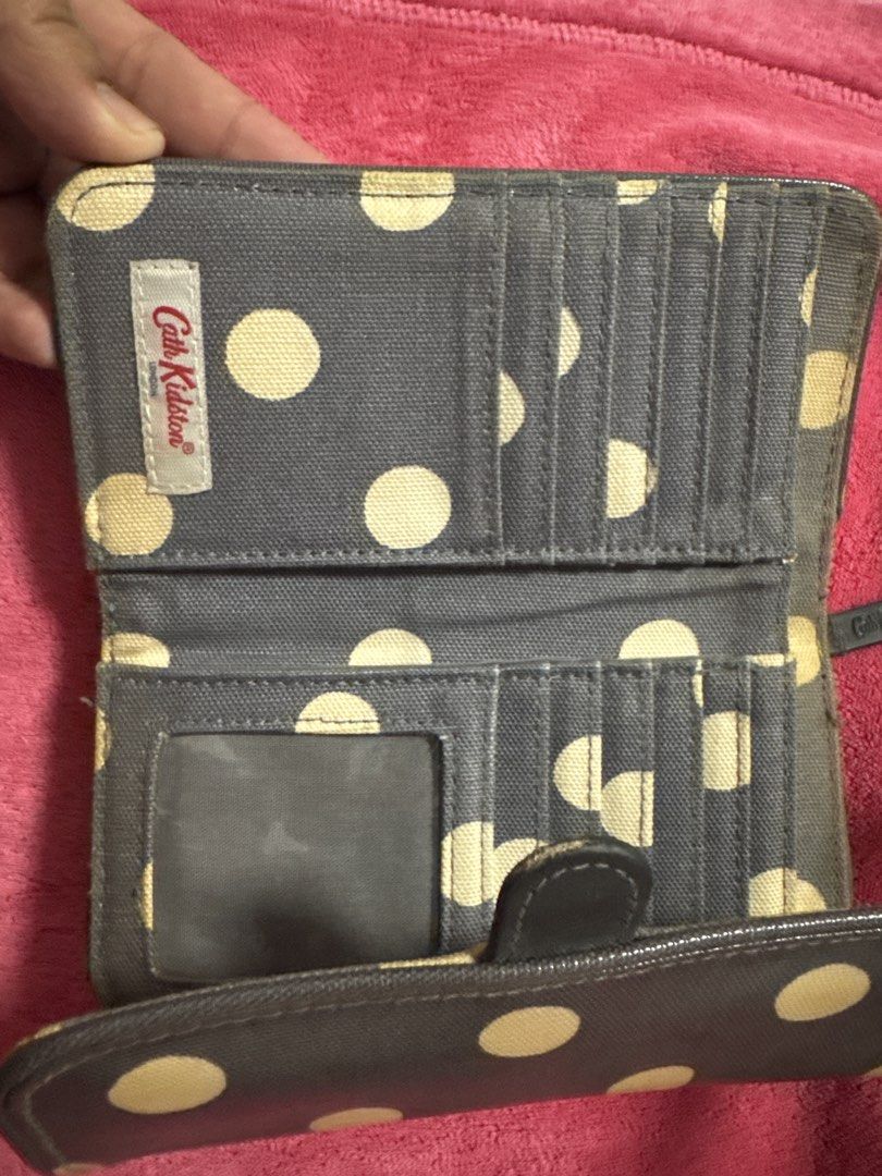 Cath Kidston Grey Polka Dot Long Wallet (Category: Wallets & Card holders) located in Manila. Submitted by baristadrinkluvr (Listing ID 1468688492, Image 2). Description: - Authentic Cath Kidston long wallet - Chic grey exterior with cream polka dots - Secure front flap with snap closure - Interior includes multiple card slots and an ID window pocket - Durable fabric lining with clean stitching throughout - Features the classic London branding ta