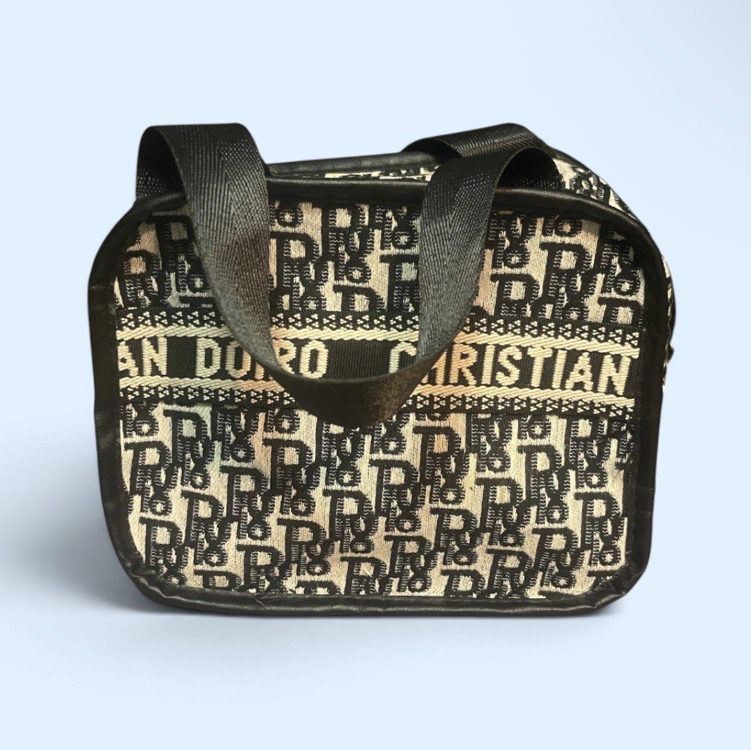 CD Black and Beige Monogram Vanity Bag OFF (Category: Purses & Pouches) located in San Pedro. Submitted by lifebeginsaftercoff33 (Listing ID 1468686924, Image 3). Description: - Color: Black and beige monogram with cream stripe and bold lettering - Shape: Structured boxy vanity bag with zip-around closure - Hardware: Silver-tone - Straps: Dual top handles - Interior: Fully lined, compact size for daily essentials - Condition: Excellent - Dimes: 7