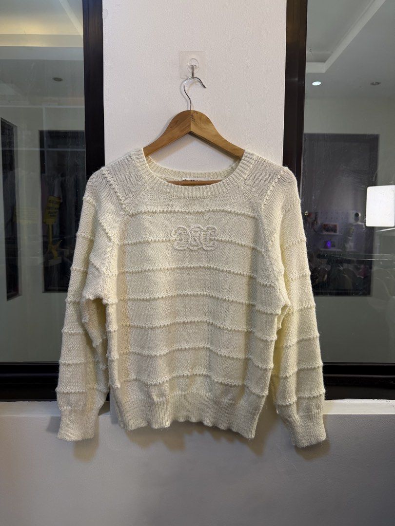 Celine Paris Off-White Striped Knit Sweater (Category: Longsleeves) located in Paranaque City. Submitted by mykapoynton (Listing ID 1468702792, Image 2). Description: - Brand: Celine Paris - Color: Cream - Material: Soft textured wool blend (warm and cozy) - Design: Horizontal ribbed stripes with embroidered chest logo - Fit/Style: Long raglan sleeves, ribbed crewneck, cuffs, and hem - Condition: Clean neckline tag attached, well-maintained.