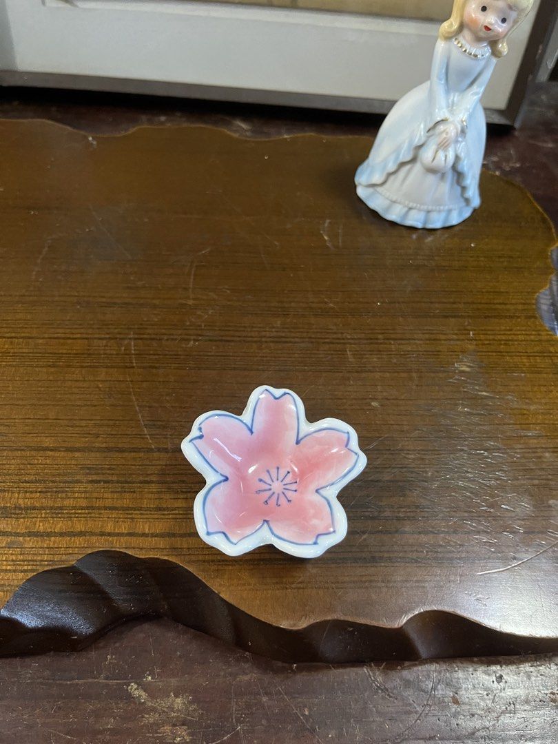 Ceramic Cherry Blossom Ring Dish Small Trinket Tray (Category: Dinnerware & Cutlery) located in Taguig. Submitted by minmin_parker (Listing ID 1468537277, Image 2). Description: - Adorable pink cherry blossom ceramic dish - Measures roughly 2.5 inches across - Hand-painted blue petal outlines with center stamens - Smooth white base underneath - Perfect trinket tray for rings, earrings, and small daily jewelry.