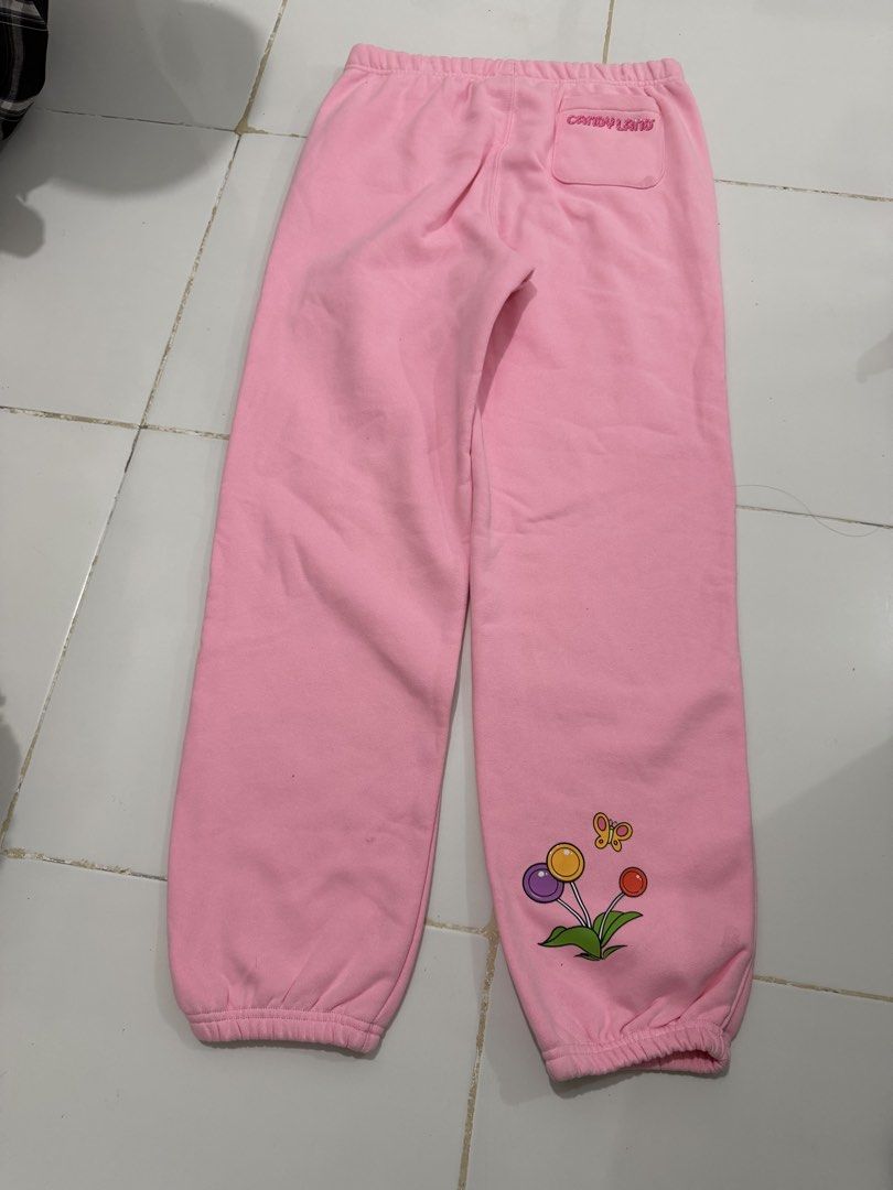 Champion Reverse Weave Candy Land Pink Sweatpants (Category: Other Bottoms) located in Manila. Submitted by xiestyleclothing (Listing ID 1468642433, Image 1). Description: - Brand: Champion Reverse Weave - Size: Medium - Color: Pink - Design: Vertical Candy Land graphics on left and lower right legs, with branding on the back pocket - Features: Elastic waistband, side pockets, and elastic ankle cuffs - Material: Cotton and polyester blend with a 