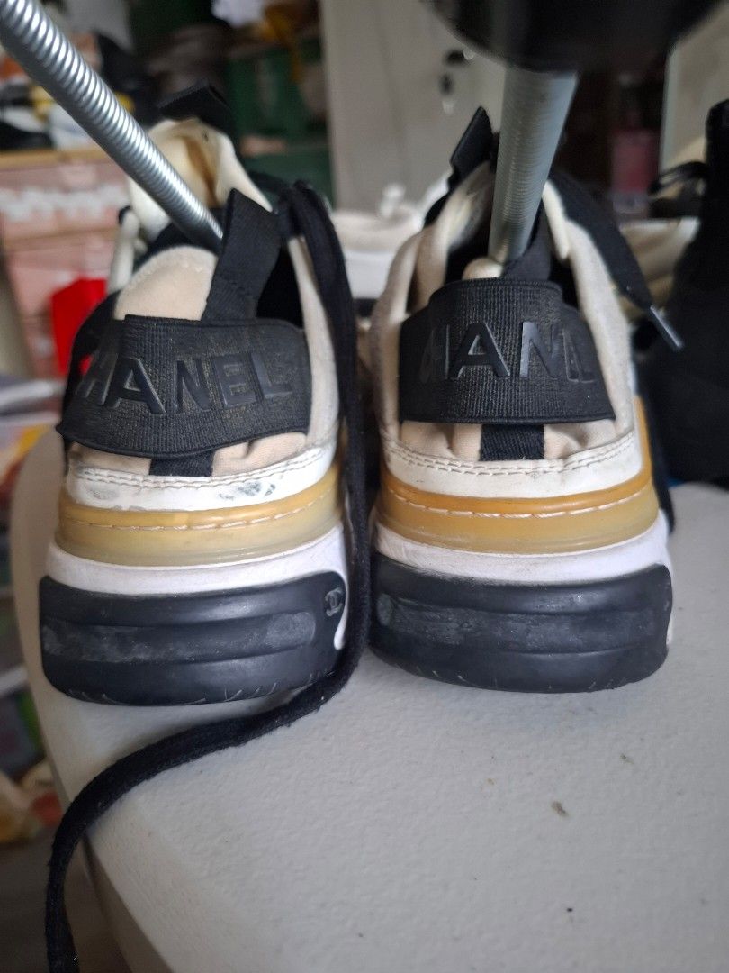 Chanel CC Logo Sneakers White Black (Category: Sneakers) located in Marikina City. Submitted by bags21.ph (Listing ID 1468503619, Image 2). Description: - Brand: Chanel - Colorway: White, Black, and Beige - Design: Iconic gold interlocked CC logo on the side with a black elastic band and Chanel lettering across the back - Materials: Suede and canvas upper panels, textured rubber sole with diamond pattern - Condition: Pre-owned, shows minor yellow