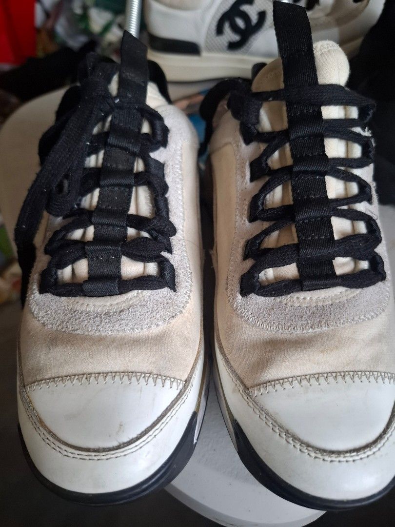 Chanel CC Logo Sneakers White Black (Category: Sneakers) located in Marikina City. Submitted by bags21.ph (Listing ID 1468503619, Image 1). Description: - Brand: Chanel - Colorway: White, Black, and Beige - Design: Iconic gold interlocked CC logo on the side with a black elastic band and Chanel lettering across the back - Materials: Suede and canvas upper panels, textured rubber sole with diamond pattern - Condition: Pre-owned, shows minor yellow