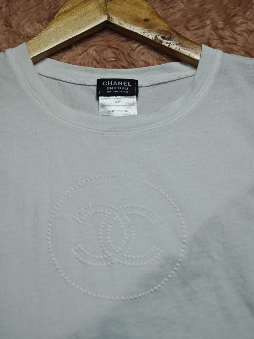 CHANEL WHITE TEES (Category: Luxury Apparel) located in Imus. Submitted by eykc01 (Listing ID 1468522579, Image 2). Description: -EUC-LIKE NEW -SMALL ON TAG -ARMPT-ARMPT: 14 INCHES -LENGHT: 23.5 INCHES **This item is an authentic Chanel Uniform Short-Sleeve T-Shirt, featuring a subtle, tonal embroidered interlocking CC logo centered on the chest.