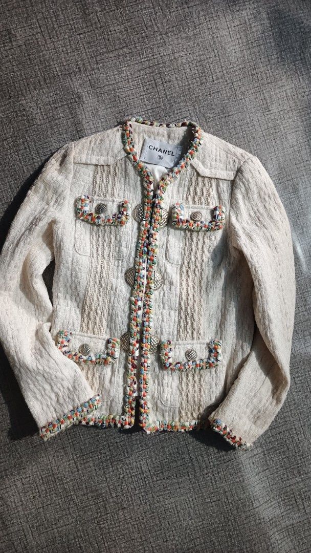 Chanel White Tweed Jacket Coat Wool Cotton (Category: Coats, Jackets and Outerwear) located in Makati City. Submitted by macdwyneki84361 (Listing ID 1468555430, Image 1). Description: - Authentic Chanel tweed jacket in elegant off-white - Premium blend of 50% wool and 50% cotton with 100% silk lining - Eye-catching multi-colored braided trim along edges, collar, and pockets - Signature quilted metal CC buttons on front closure and four patch pock