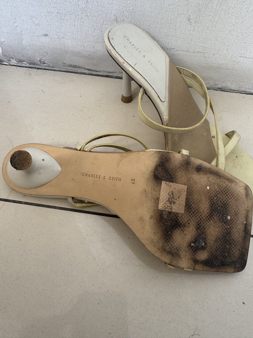 Charles & Keith Yellow Strappy Heels Size 37 (Category: Heels) located in Manila. Submitted by decluterthings888 (Listing ID 1468579224, Image 2). Description: - Brand: Charles & Keith - Color: Pale Yellow - Size: 37 - Design: Square toe, thin stiletto heel, and delicate strappy details - Condition: Pre-loved with noticeable wear on white insoles, straps, and heavily scuffed soles from regular use - Authenticity: Branding stamped on insole and ou