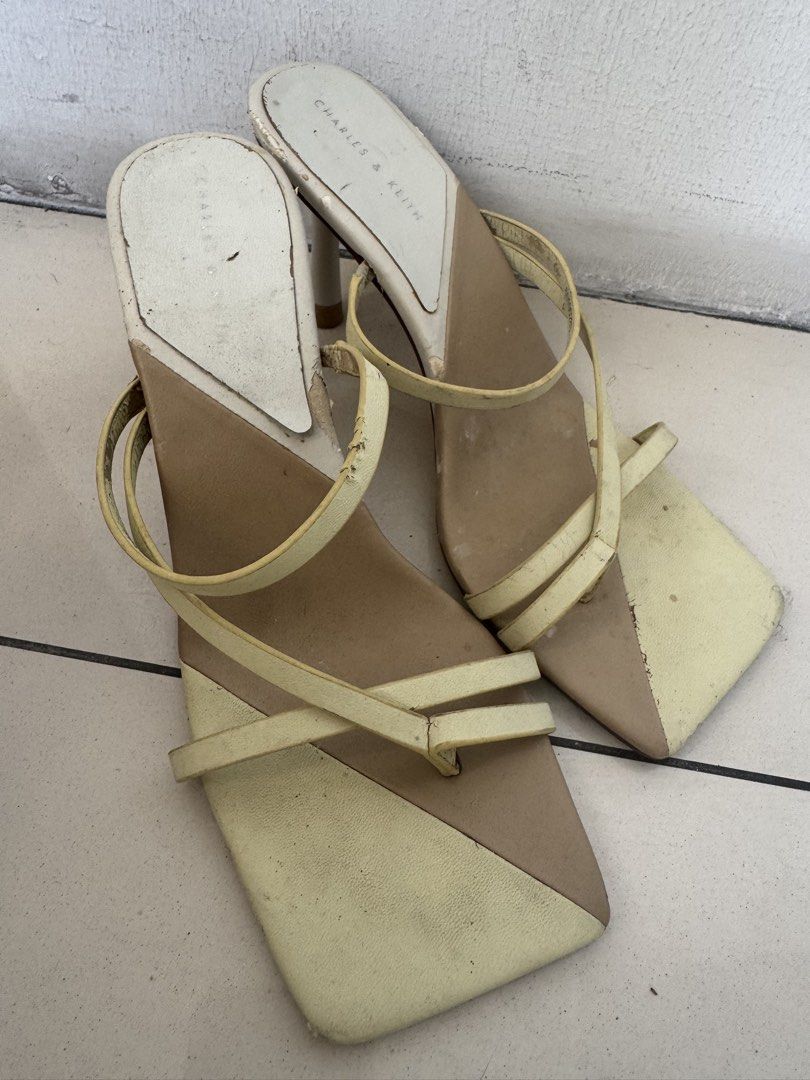 Charles & Keith Yellow Strappy Heels Size 37 (Category: Heels) located in Manila. Submitted by decluterthings888 (Listing ID 1468579224, Image 1). Description: - Brand: Charles & Keith - Color: Pale Yellow - Size: 37 - Design: Square toe, thin stiletto heel, and delicate strappy details - Condition: Pre-loved with noticeable wear on white insoles, straps, and heavily scuffed soles from regular use - Authenticity: Branding stamped on insole and ou