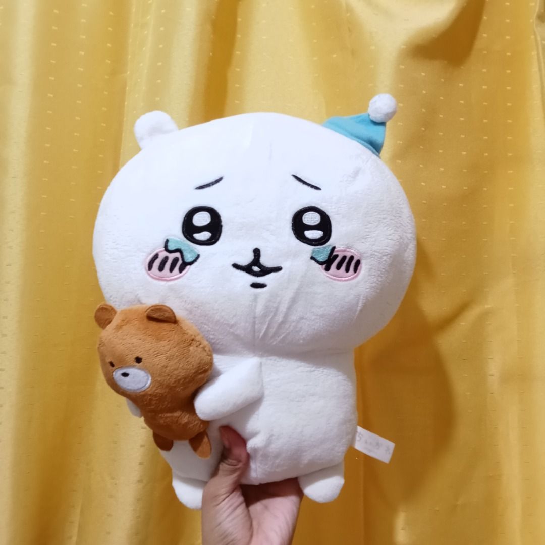 Chiikawa plush toy with small bear (Category: Plushies & Soft Toys) located in Quezon City. Submitted by trinket_cat (Listing ID 1468578384, Image 1). Description: - Character: Chiikawa holding a brown bear wearing a tiny blue hat - Condition: Brand new with side tag attached, super soft fabric, and clean surface - Storage: Kept safely away from dust in a smoke-free environment - Perfect for: Chiikawa fans and plush toy collectors.