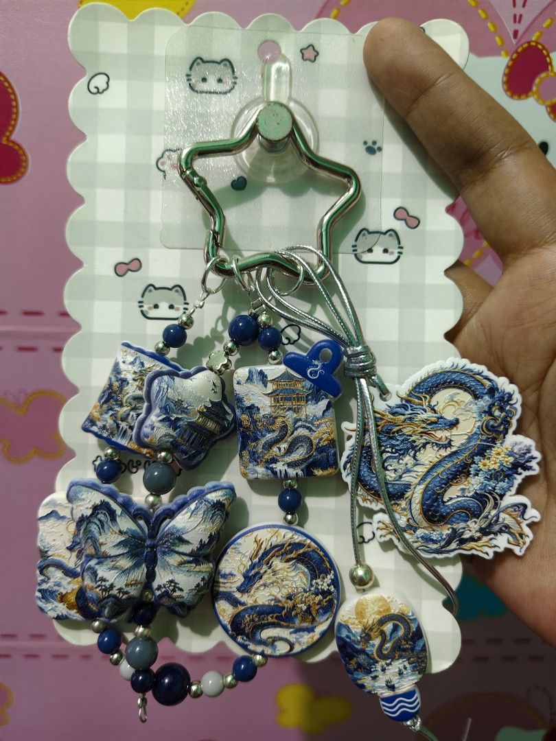 Chinese Dragon Butterfly Keychain (Category: Charms) located in Rizal. Submitted by yves1211 (Listing ID 1468670127, Image 2). Description: - Blue and white beads design with intricate traditional motifs - Features detailed dragon and butterfly charms with gold accents - Includes decorative beads and a secure silver star-shaped clasp - Comes on a decorative backing card, great for gifting - Versatile accessory for bags, keys, or wallets.