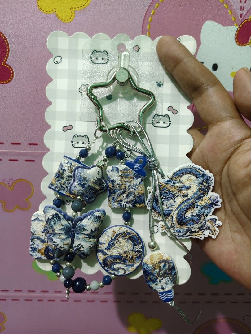 Chinese Dragon Butterfly Keychain (Category: Charms) located in Rizal. Submitted by yves1211 (Listing ID 1468670127, Image 1). Description: - Blue and white beads design with intricate traditional motifs - Features detailed dragon and butterfly charms with gold accents - Includes decorative beads and a secure silver star-shaped clasp - Comes on a decorative backing card, great for gifting - Versatile accessory for bags, keys, or wallets.