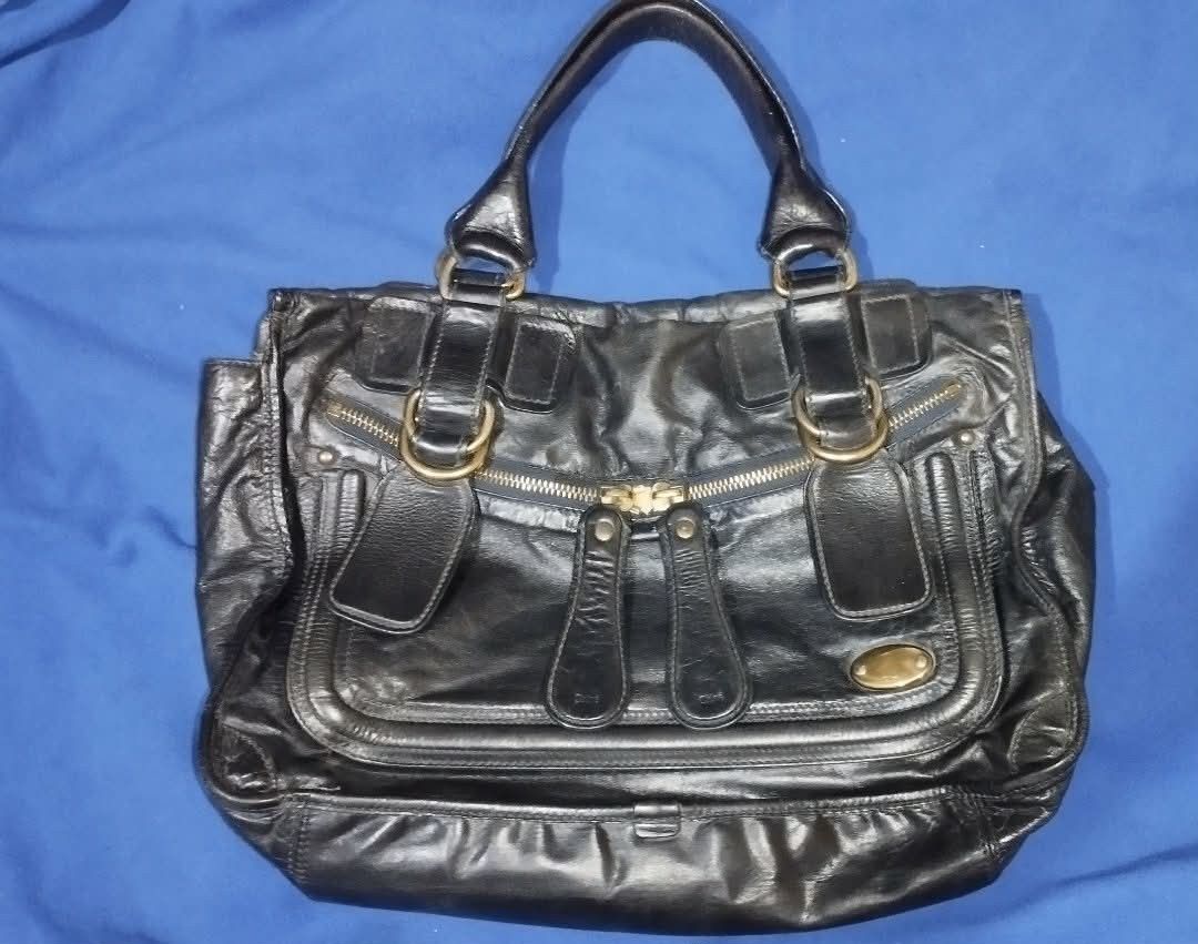 Chloé Black Leather Shoulder Bag (Category: Luxury Bags & Wallets) located in Manila. Submitted by beckster_nnline_luxuryshop (Listing ID 1468618683, Image 1). Description: - Authentic black leather Chloé handbag - Elegant gold-tone hardware de tails - Double top handles for easy carrying - Convenient front zip pocket - Spacious beige fabric interior - Stamped Chloé logo and serial tag inside - Made in Italy price Slightly Negotiable, message me 