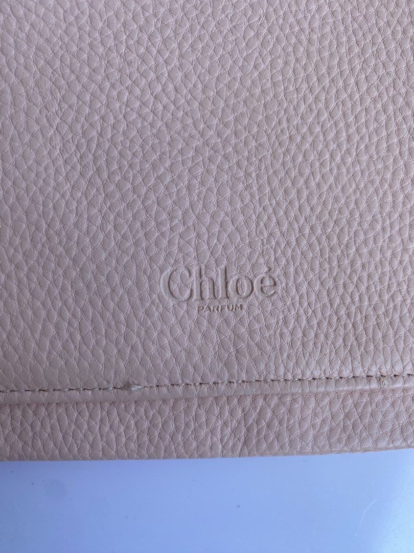 Chloé Parfum Pink Pouch Makeup Bag (Category: Purses & Pouches) located in Cavite. Submitted by benta_bounce (Listing ID 1468556928, Image 3). Description: - Authentic Chloé Parfum pink pouch - Features chic gold-tone hardware and debossed logo text on the front - Zipper closure with a matching pull tab and branded metal charm (protective plastic still attached) - Includes a convenient front pocket - Flaw note: Some peeling and cracking along the