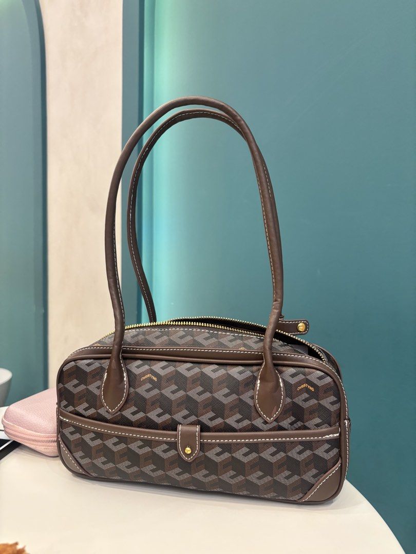 Christy Ng brown geometric patterned shoulder bag (Category: Shoulder Bags) located in Paranaque City. Submitted by ciangggg (Listing ID 1468662953, Image 2). Description: - Brand: Christy Ng - Style: Geometric print shoulder bag in brown - Condition: Brand new with tags attached - Closure: Secure top zip closure - Pockets: Front slip pocket with snap tab closure - Details: Contrasting white stitching on brown trim, dark hardware, and clean inter